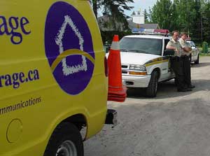 3 juillet 2003 : deux voitures de la Sûreté du Québec escortent un camion de télécommunications venu débrancher les voisins.